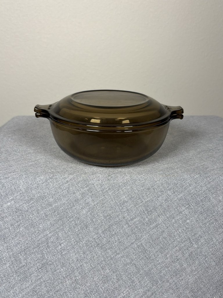 An amber Pyrex round casserole dish with a lid photographed for a US resale marketplace listing